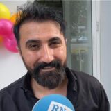 Erhan Mert spricht vor seiner Dönerbude in Dortmund in einem Mikrofon.