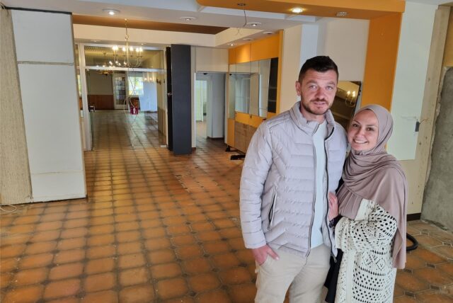 Ein Mann und eine Frau stehen in einem leeren Ladenlokal.
