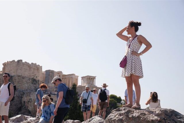 Touristen auf dem Aeropagous-Hügel vor der antiken Akropolis im Zentrum Athens.