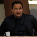 Tamas Hajnal nimmt auf einem Stuhl Platz.