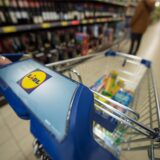 Ein gefüllter Einkaufswagen steht im Gang im Supermarkt.