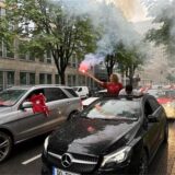 Eine Frau jubelt aus einem Wagen.