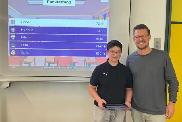 Schüler und Lehrer vor einem digitalen Board