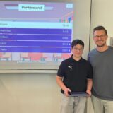 Schüler und Lehrer vor einem digitalen Board