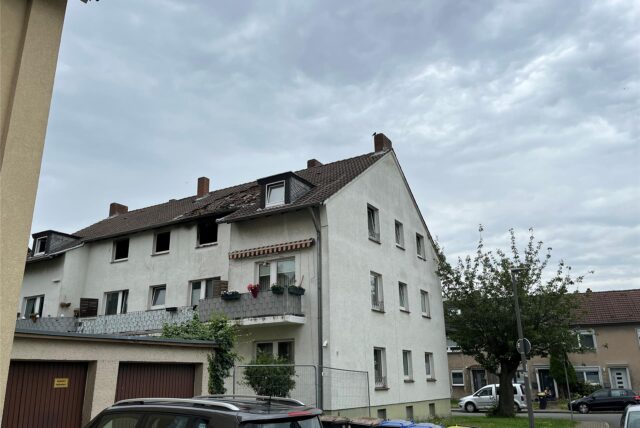 Ein Wohnhaus mit einem großen Brandloch im Dach.