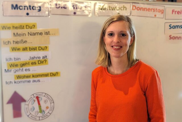 Lehrerin Denise Vreden steht vor einer weißen Tafel.