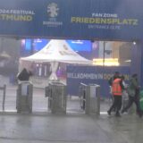 Am Eingang zum Public Viewing auf dem Friedensplatz suchen die Menschen das Trockene.