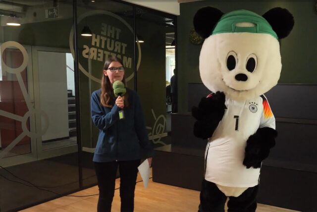 Unsere Volontärin Katharina Göke steht neben dem Panda.