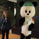 Unsere Volontärin Katharina Göke steht neben dem Panda.