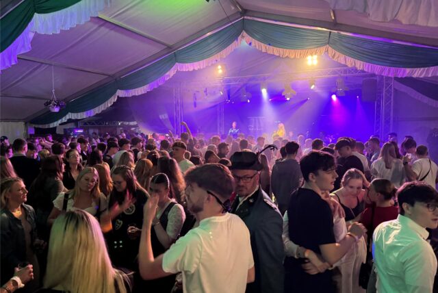 Menschen feiern in einem Festzelt.