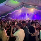 Menschen feiern in einem Festzelt.