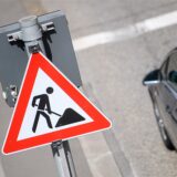 Ein Auto steht neben einem Baustellenschild.