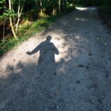 Schatten eines Mannes auf einem Waldweg