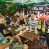 Eine Mitarbeiterin von „Hopfen & Salz“ in Dortmund-Lütgendortmund serviert Besuchern des Biergartens Getränke.