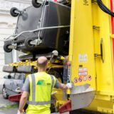 Ein Mitarbeiter der EDG entleert eine Tonne an einem Müllwagen.