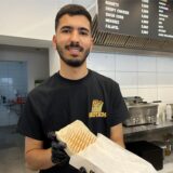 Nassir Tamouh hält einen French Taco in die Kamera.