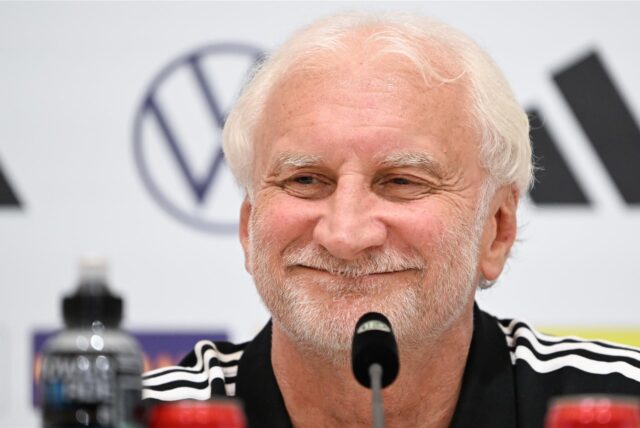 Rudi Völler lacht bei der Pressekonferenz.