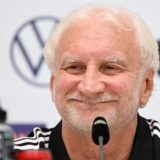 Rudi Völler lacht bei der Pressekonferenz.