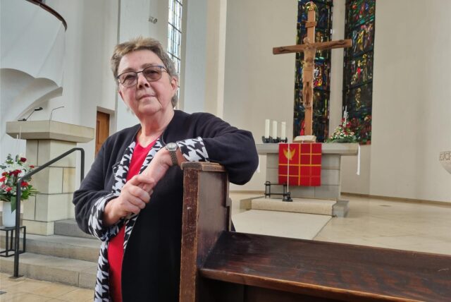 Eine Frau steht in einer Kirche
