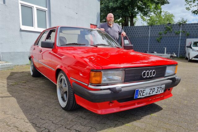 Ein Mann steht an einem Auto