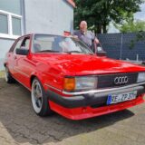 Ein Mann steht an einem Auto