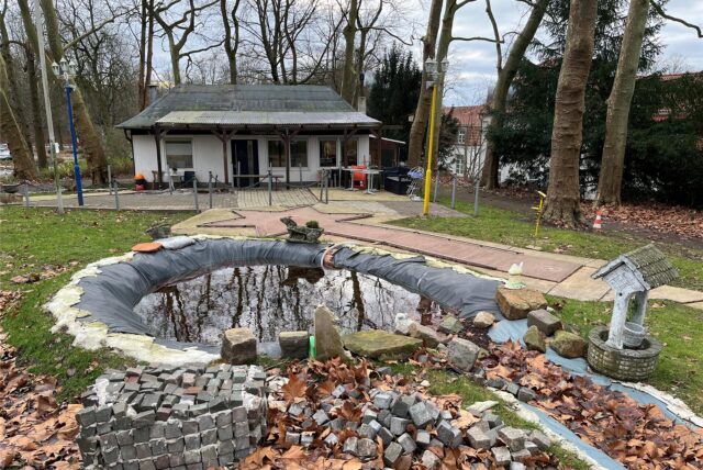 Ahmet Gül steht mit einem Minigolfschläger in der Hand auf seiner selbst renovierten Minigolfanlage in Castrop-Rauxel.