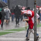 Fußball-Fans gehen durch den Regen.