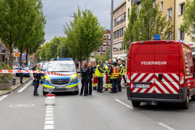 Einsatzkräfte von Polizei und Feuerwehr stehen am abgesperrten Tatort in Bochum.