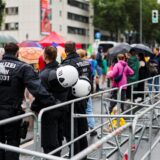 Drei Polizisten beobachten etwa 150 Demonstranten hinter einer Absperrung an der Grugahalle in der der AfD-Bundesparteitag fortgesetzt wird.