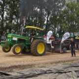 Ein Traktor zieht eine Maschine hinter sich her.