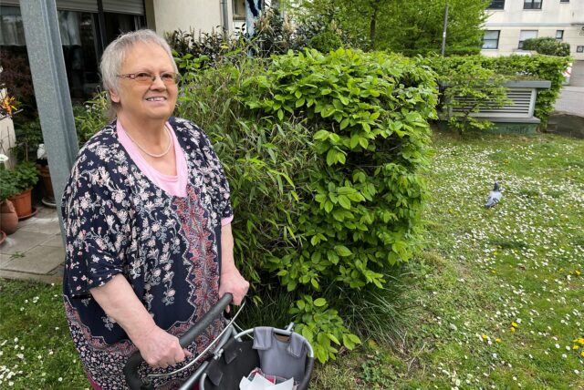 Heide WIttrien steht an der Wiese ihrer Wohnung.