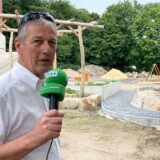 Michael Vaupel steht mit einem Mikrofon in der Hand auf dem Außengeländer des neuen Kindergartens in Herten-Disteln.