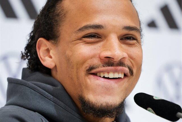 Leroy Sané sitzt vor einem Mikrofon.