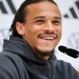 Leroy Sané sitzt vor einem Mikrofon.