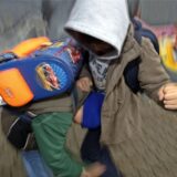 Zwei Jungen mit Schultaschen auf dem Rücken kämpfen miteinander. (Symbolbild)