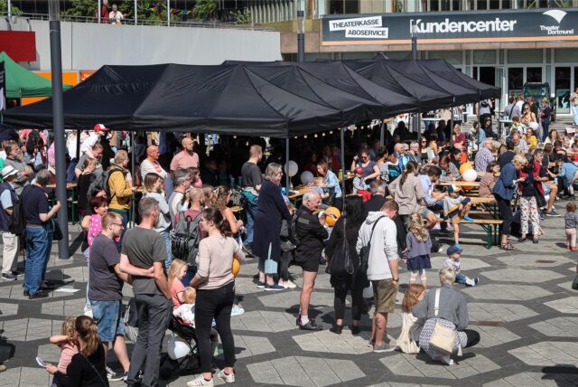 Besucher stehen beim Theaterfest in Dortmund auf dem Vorplatz des Theaters.