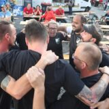 Impression bei der Castropiade 2023 auf dem Marktplatz in Castrop:Teamteilnehmer stehen Arm in Arm im Kreis.