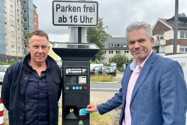 Dezernent Axel Fritz und Sachgebietsleiter Thorsten Reimann stehen neben einem Parkautomaten in Recklinghausen.
