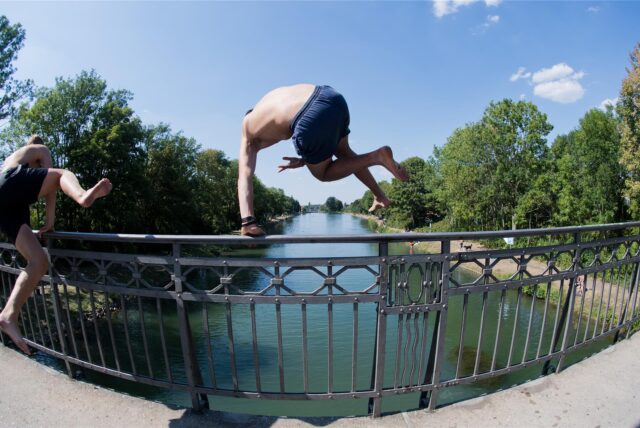 Zwei Männer springen von einer Brücke ins Wasser