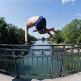 Zwei Männer springen von einer Brücke ins Wasser