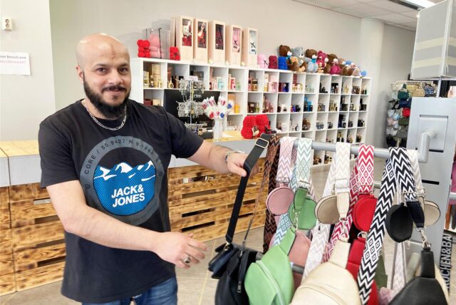 Abbas Ayad steht in seinem Ladenlokal in der Hertener Innenstadt und richtet einen Verkaufsstand mit Handtaschen her.