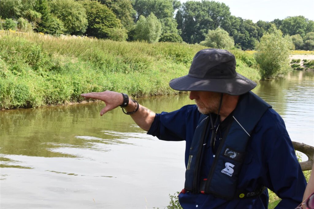 Ein Schwimmbagger gräbt auf der Lippe am Ufer.