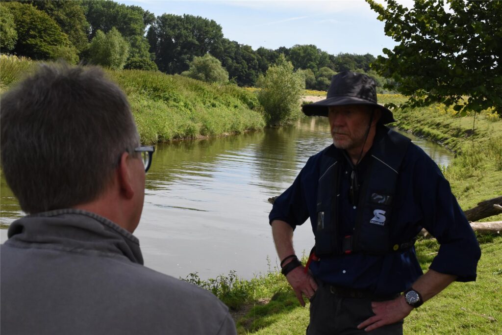 Ein Schwimmbagger gräbt auf der Lippe am Ufer.