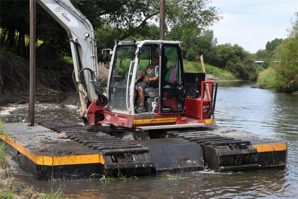 Ein Schwimmbagger gräbt auf der Lippe am Ufer.