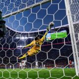 Der französische Keeper Mike Maignan liegt quer in der Luft. Der Ball fliegt an ihm vorbei ins Tor.