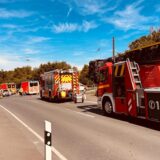 Einsatzfahrzeuge stehen auf einer Straße, im Hintergrund sind zwei beschädigte PKW zu sehen.