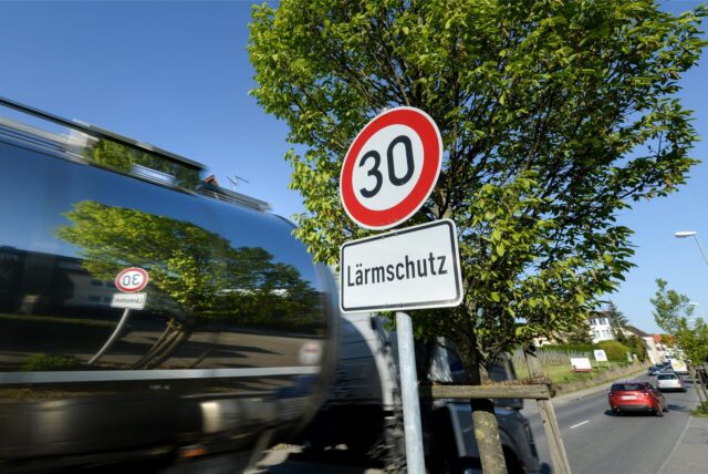 Ein Schild, das auf Tempo 30 und Lärmschutz hinweist, steht auf einer Bundesstraße.