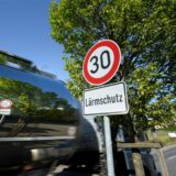 Ein Schild, das auf Tempo 30 und Lärmschutz hinweist, steht auf einer Bundesstraße.