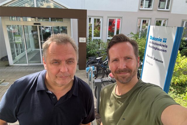 Die RZ-Redakteure Ralf Wiethaup (links) und Tobias Mühlenschulte stehen vor dem Eingang der Diakonie im Kirchenkreis Recklinghausen am Elper Weg.