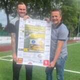 Zwei Männer halten ein Plakat hoch.